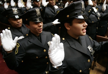 Damarie Acevedo, right, takes the oath of office at the graduation ceremony for Newark Police Department's 114th recruit class Tuesday in Newark. Fifty-eight recruits were sworn in as police officers. SARAH SIMONIS/FOR THE STAR-LEDGER