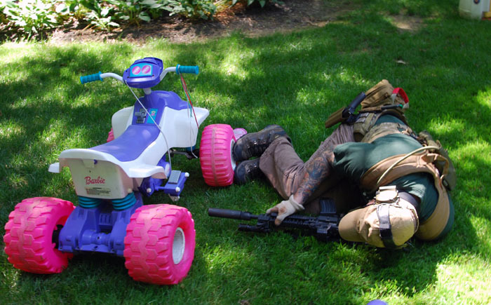 Merrill taking cover behind a Barbie 4-wheeler.