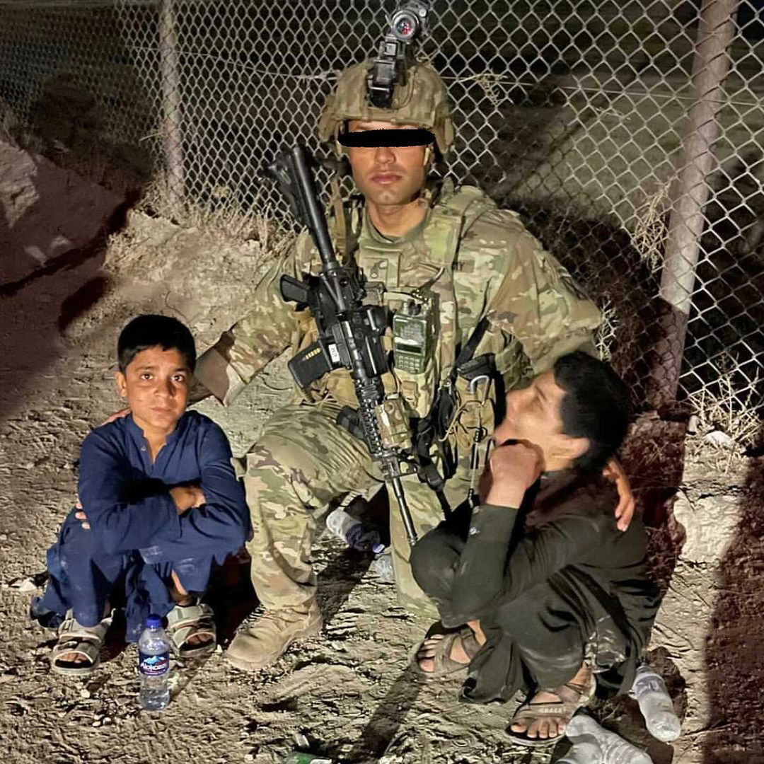 A soldier from 4th Platoon, D Company ("Punishers"), 34th Infantry of the 10th Mountain Division and two local youngsters he has temporarily been charged with looking after. 