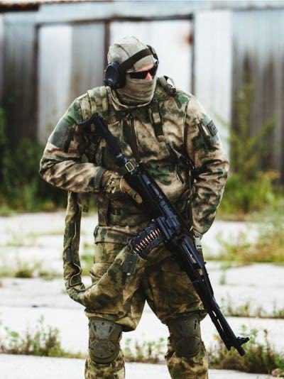 A machine gunner feeding his weapon from a backpack. 