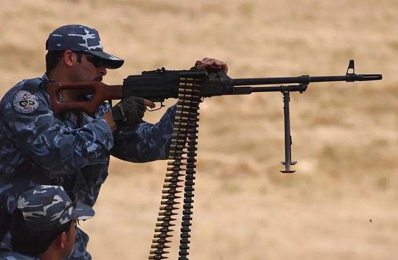 Soldier Kurdish Peshmerga holding a PKM belt fed machine gun.