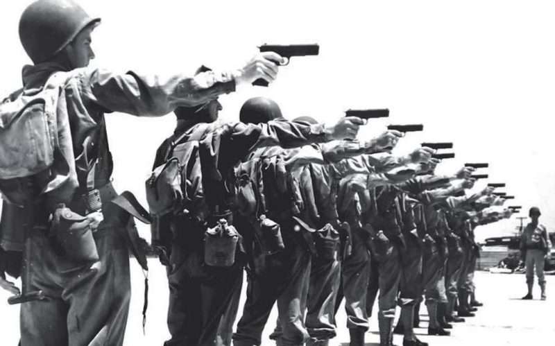 GIs on the firing line with WII era M1911A1 pistols. The War Department's demands necessitated a much broader production base than Colt alone (or even Colt, Remington, Savage Arms, Springfield Armnory, and Ithaca Gun Company together) could provide. Hundreds of thousands of the pistols were manufactured during the war, including many built by typewriter, railroad equipment, and sewing machine companies.