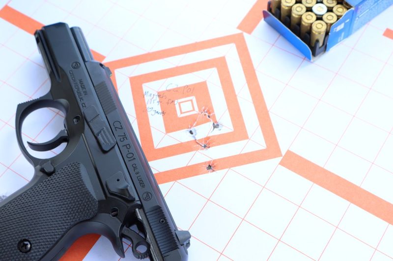 cz p01 pistol on a paper target with an open box of ammunition