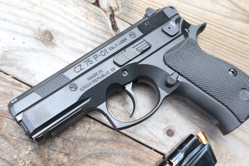 the cz p01 pistol on a table with an extra magazine