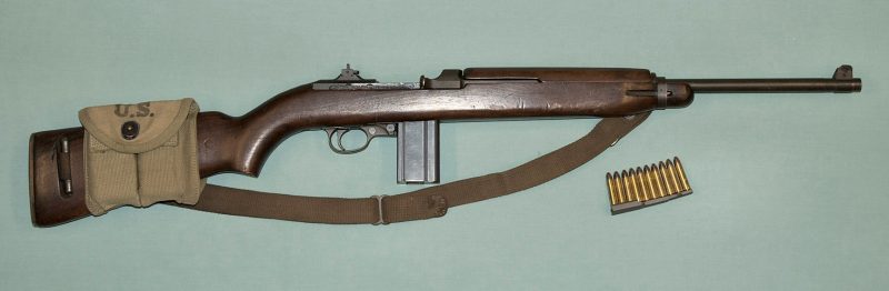 An original WW2 M1 Carbine, with buttstock mag pouch and 30-cal carbine rounds "spooned up."