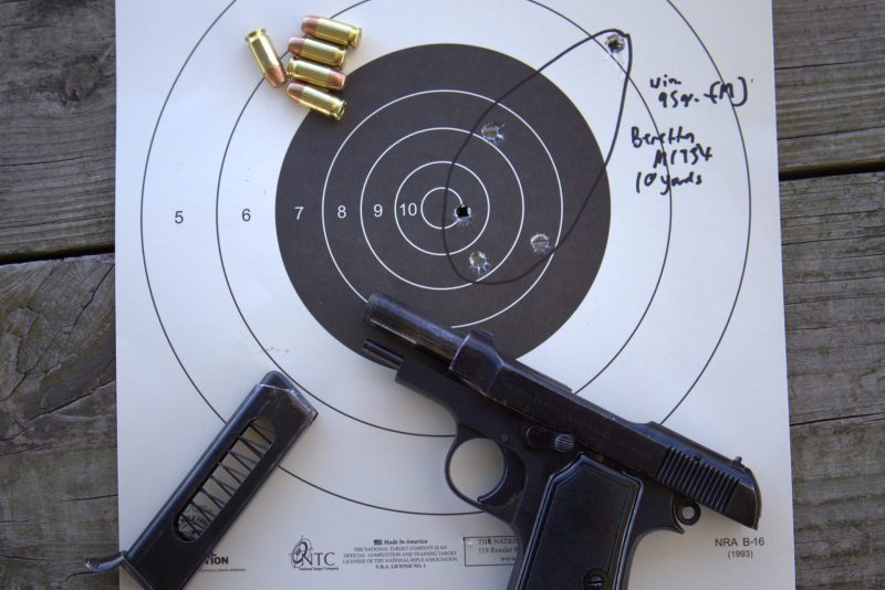 beretta model 1934 pistol with a paper target, ammunition, and the empty magazine