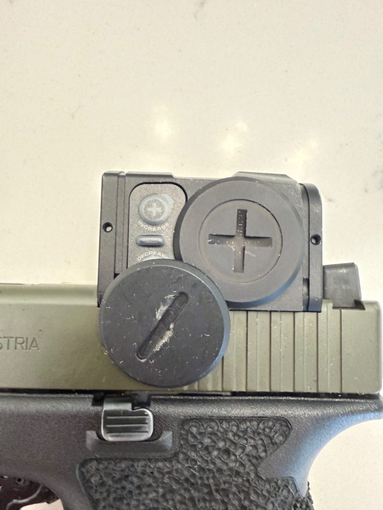 Aimpoint factory battery cover comparison with Tango Down metal optic cover upgrade on Glock-mounted red dot.