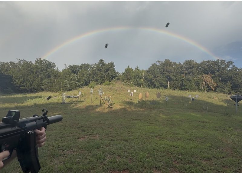 Suppressed SP5K shooting at an outdoor range with brass casings flying over the rainbow present.